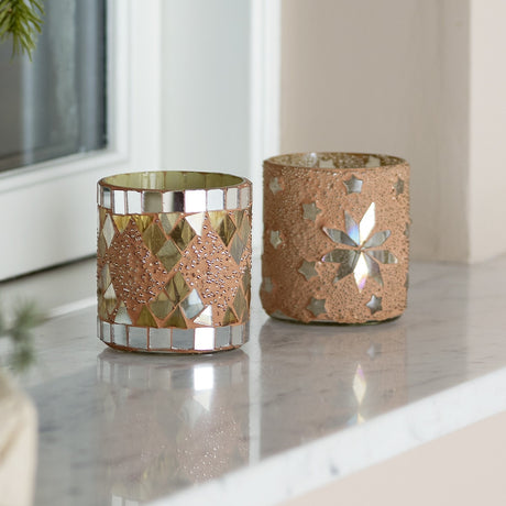 Miya round glass tealight holders, set of 2 in nude, one with mosaic diamond tiles, the other with a star motif, on a marble windowsill.
