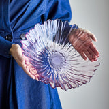 Mariko Flower Glass Bowl 31cm in pink, held in both hands, showing its wavy ruffled rim, petal-like grooves, and beaded textured centre.