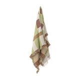 Galvin Checked Cotton Throw in a multicoloured green, brown, and beige check with fringed edges, shown draped against a plain white background.