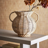 Uni Glass Vase 25.5cm in brown, a two-handled woven rattan urn with a round body and flared neck, shown with dried flowers on a wooden console table.