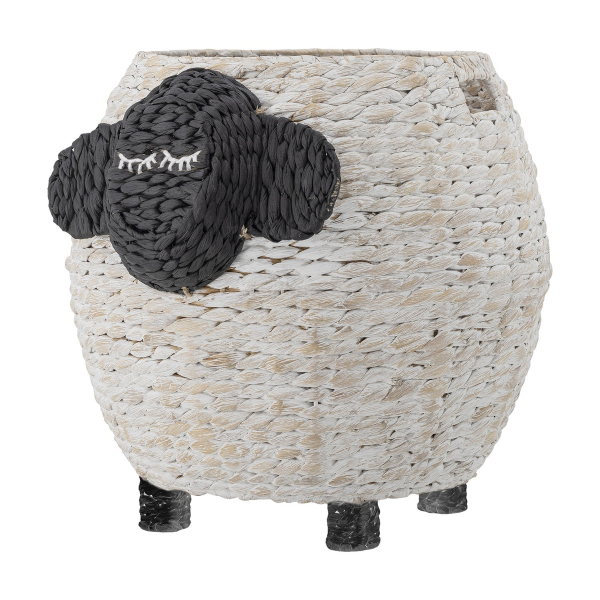 Dolly Sheep water hyacinth storage basket in white with a dark woven face, closed-eye stitched lashes, two ears, and short woven legs, on a plain background.