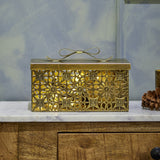 Gretl gold iron Christmas storage box with lid, featuring floral and geometric openwork sides and a bow-shaped lid detail, shown on a marble surface.