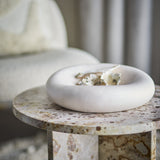 Audra Pebble Stoneware Bowl 30cm in white, a wide, rounded ceramic bowl with speckled glaze, shown on a stone side table beside an upholstered chair.