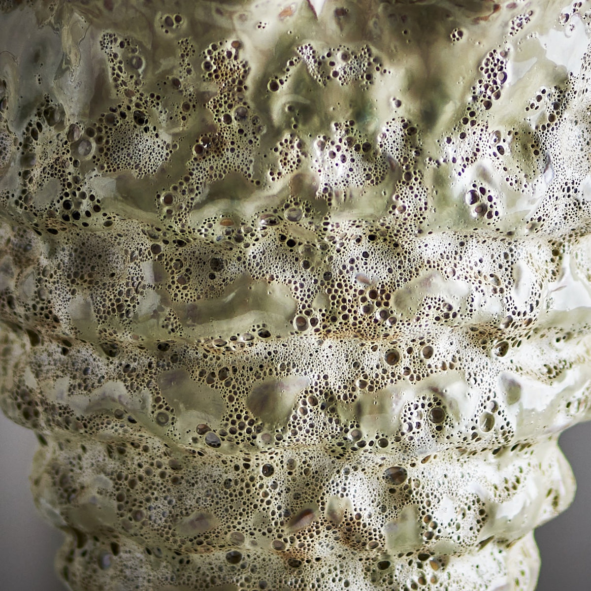 Close-up of the Colleen Wavy Stoneware Plant Pot in cream, showing stacked ridges and a heavily bubbled, pitted ceramic glaze texture.