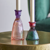 Shilo Ribbed Glass Candle Holders, set of 2, tall pink and shorter green bell-shaped bases with beaded edges, holding white taper candles on a brass table.