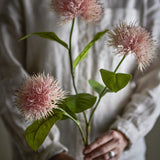Chrysanthemum Artificial Stem 100cm in pink, held by a person in a cream shirt, showing three spiky round blooms, green leaves, and branching stems.