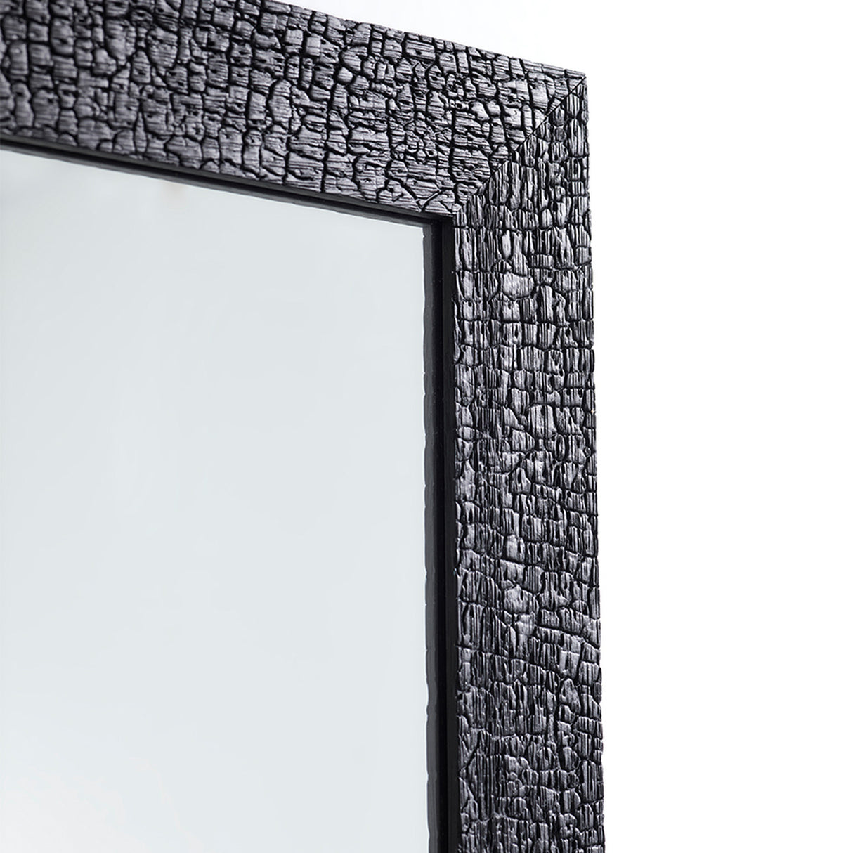 Close-up of the charred frame seen at an angle, showing the depth of the crackle running along the timber edge.