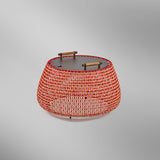 Nans Bag/38/R rechargeable outdoor floor lamp, wide woven basket-style shade in red, orange and beige fabric with dark flat top and two wood handles, on a plain light grey background.