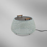 Nans Bag/38 Wood LED outdoor floor lamp with a wide woven beige shade, flat dark top, and two teak carry handles, shown on a plain grey background.