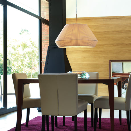 Mei 60 Ribbon Cone Pendant Light with a wide, pleated cream translucent shade over a tapered iron frame, hanging above a dining table in a wood-panelled room.