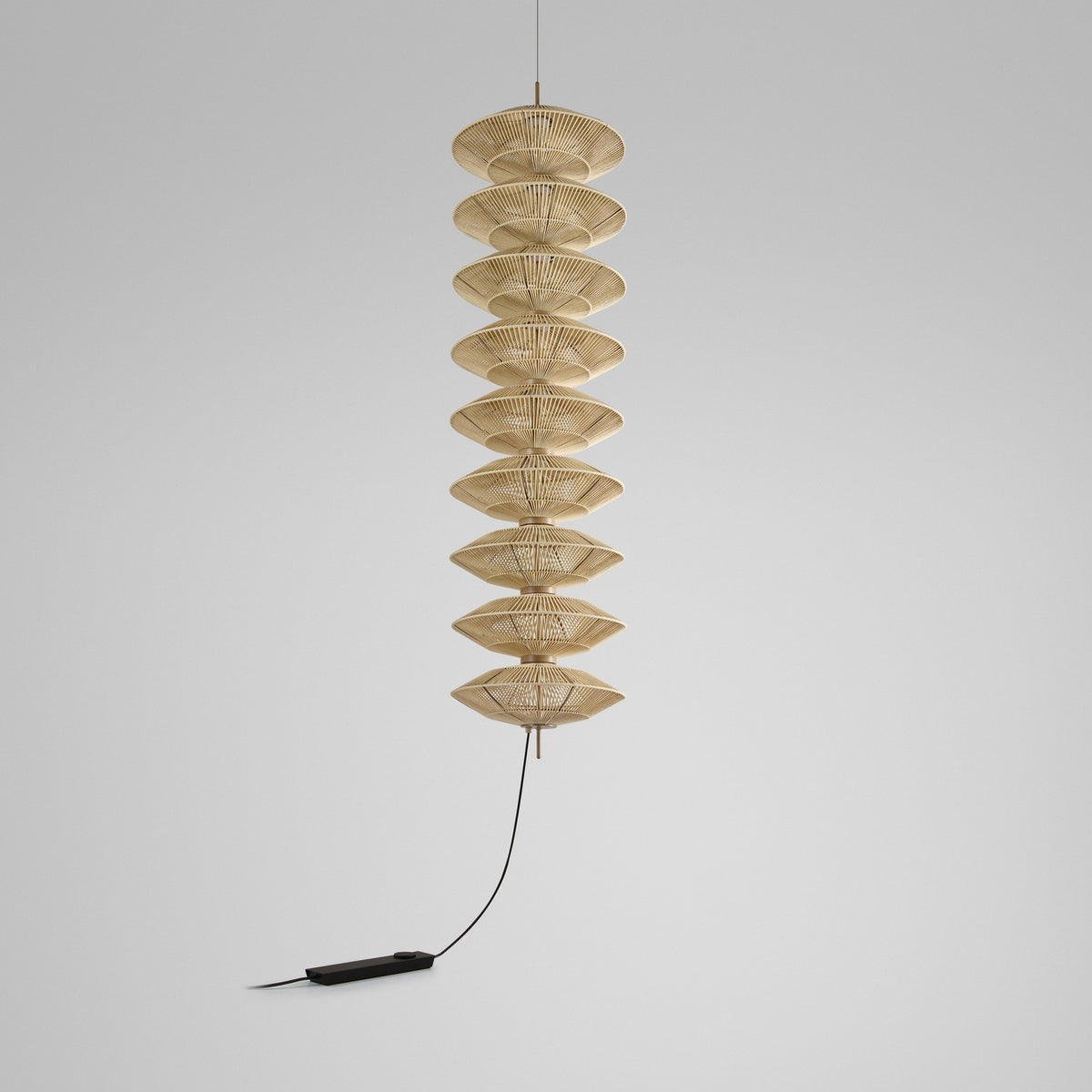Yuyun S/9L/I fabric LED pendant light with nine stacked woven beige cotton tiers on a slender stem, satin beige finish, shown against a plain light grey background.
