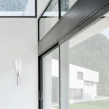 Ypsilon Recessed LED Wall Light in white, a slim vertical fitting mounted beside glazed sliding doors in a modern interior with hills visible outside.