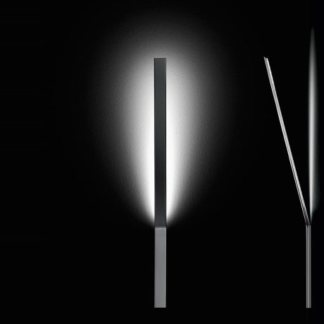 Ypsilon LED Wall Light in chrome, slim rectangular blade angled upward from a wall-mounted block, casting an upward glow against a black background.