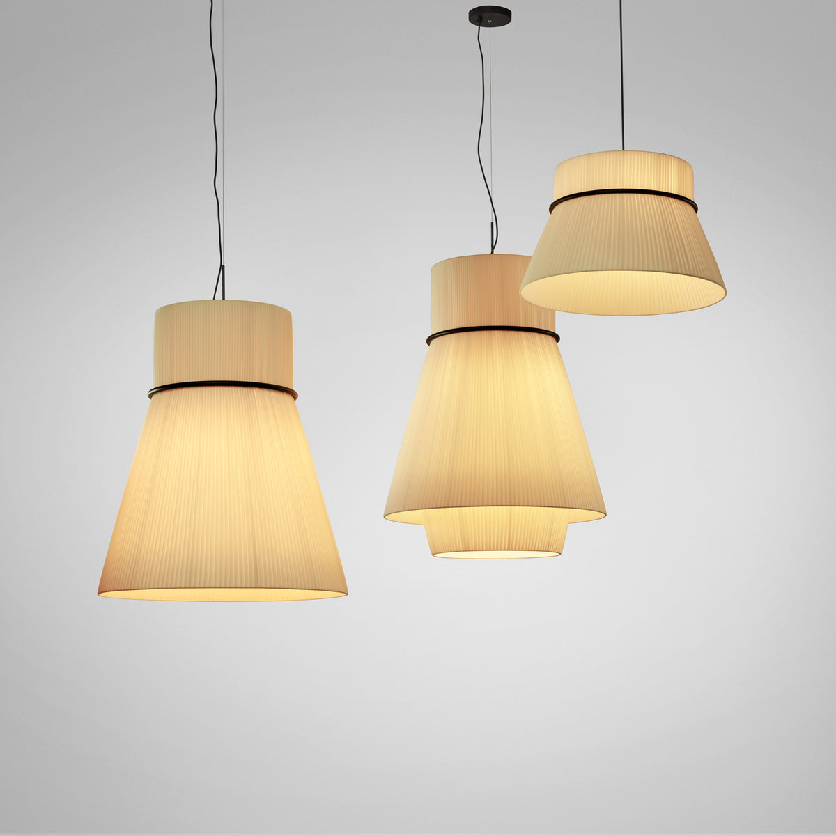 Folie S/70.2 Ribbon Tiered Pendant Light in Cream, shown among matching conical pendants with pleated fabric shades and black trim rings, lit against a plain grey background.