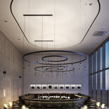 Skybell Circle Iron Ring LED Pendant Light in Ebony Black, with three tiered rings and cone-shaped heads on slim stems, shown suspended above a restaurant bar.