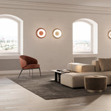 Superbold LED Wall & Ceiling Light 44.3cm in round disc design shown in a living room, two mounted side by side in bronze and champagne finishes with a soft white glowing ring.