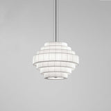 Mos 02 Ribbon Tiered Pendant Light with seven stepped pleated tiers in white translucent ribbon shade, iron structure, round canopy, shown on a plain grey background.