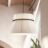 Folie S/60 Ribbon Tiered Pendant Light in White, with pleated two-tier drum shade and dark ring join, hanging in a room with vaulted brick ceiling.