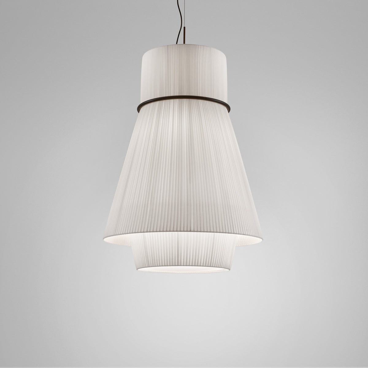 Folie S/70.2 tiered pendant light with white pleated ribbon shade, cylindrical top and flared cone tiers joined by a black ring, shown on a plain grey background.