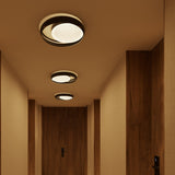 Ring C45 Glass Ring Ceiling Light in black finish, flush-mount design with offset ring frame and glowing round disc, shown in three sizes along a wood-panelled hallway.