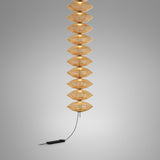 Yuyun S/11L/I pendant light with eleven stacked satin beige thread shades on a slim stem, illuminated, with black cord and foot dimmer, on a plain grey background.