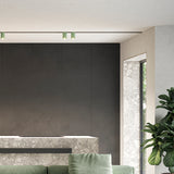 432 Ways Street cylinder track ceiling light in green, mounted on a ceiling track above a dark kitchen wall and marble counter, integrated LED, modern style.