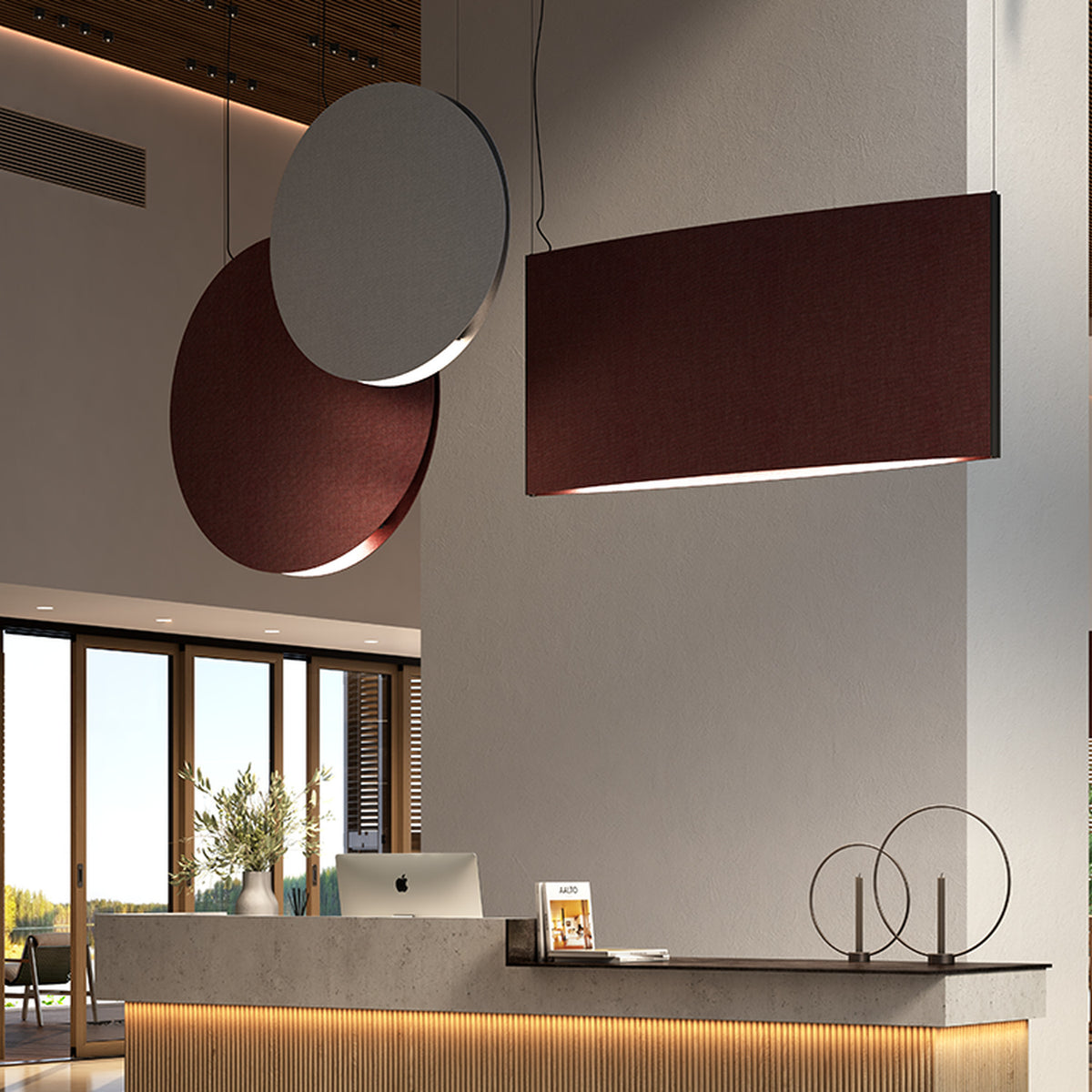 Noren S/100 fabric disc LED pendant light in Light Grey, a round panel with a glowing lower edge, shown alongside a rectangular burgundy pendant above a reception desk.