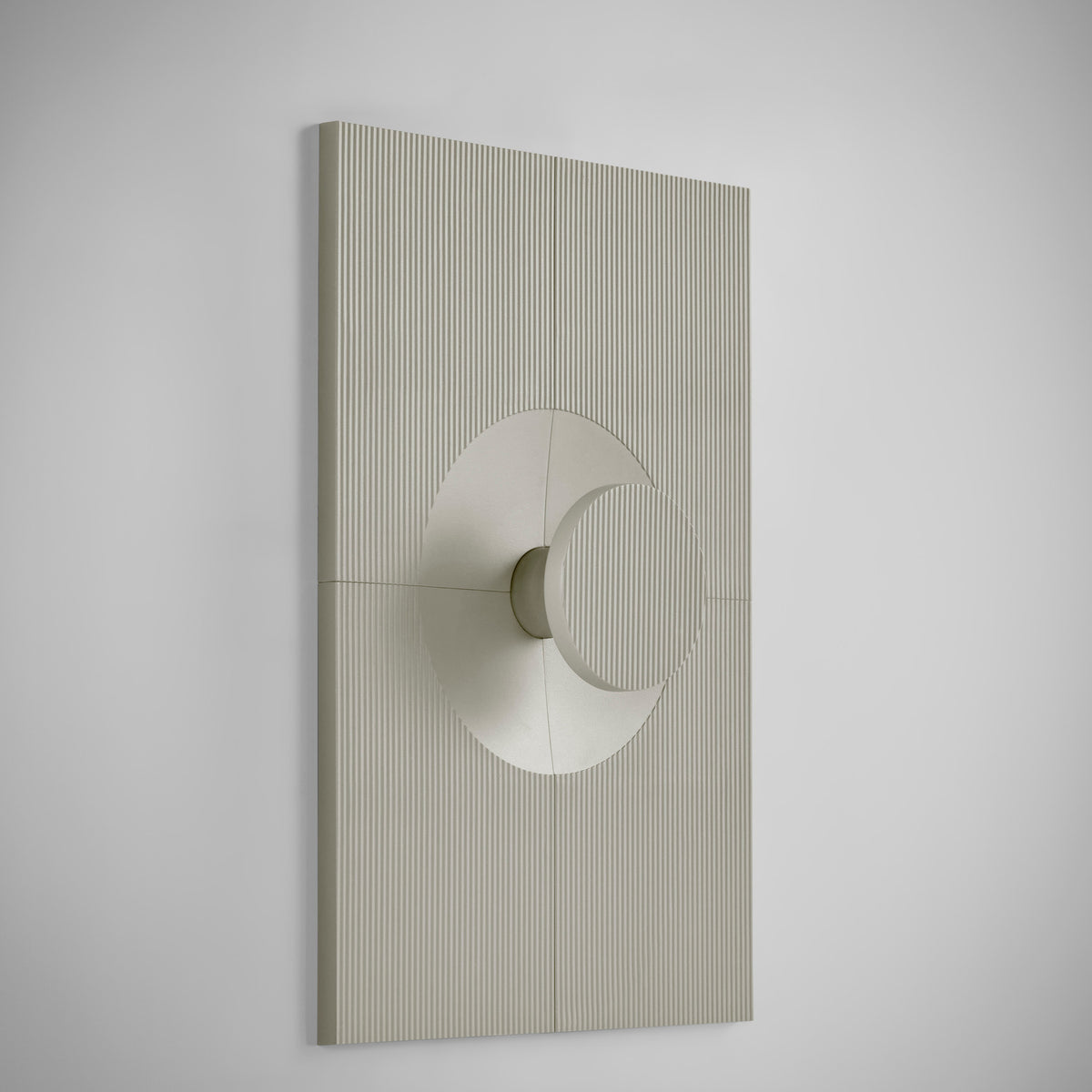 Arid Wall Light Tile in Textured Pebble Grey aluminium, a rectangular fluted panel with a smooth curved circular cutout at centre, shown at an angle against a plain white background.