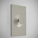 Arid Wall Light Tile in Textured Pebble Grey aluminium, a rectangular fluted panel with a smooth curved circular cutout at centre, shown at an angle against a plain white background.