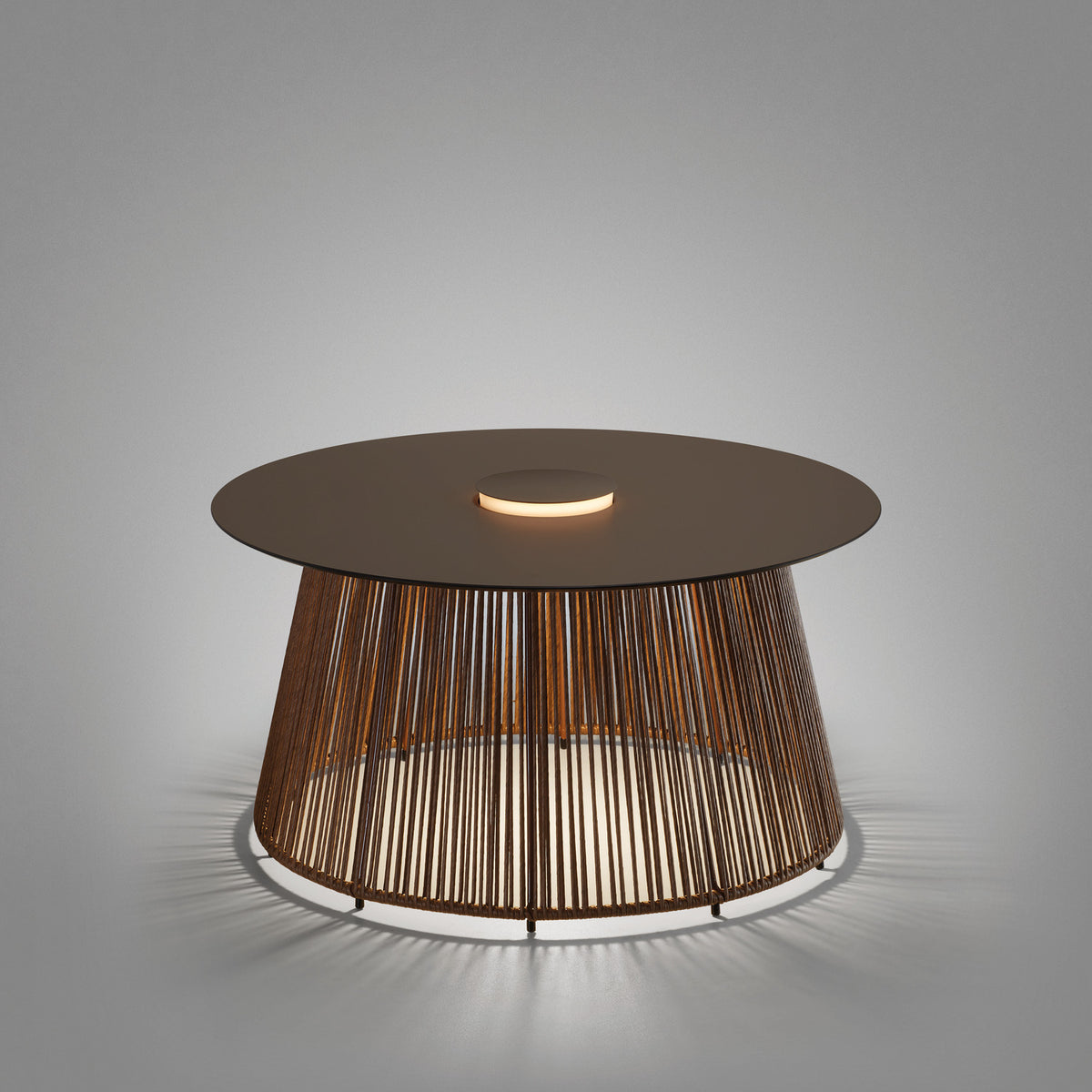Nit/80/R rechargeable outdoor table lamp with round stone-brown top, woven synthetic fibre drum base, and integrated LED ring glowing through the cords, shown on a plain grey background.