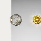 Murané wall and ceiling light with a 10cm rippled smoke grey glass globe on a brushed champagne half-dome plate, integrated warm white LED, shown against grey and white backgrounds.