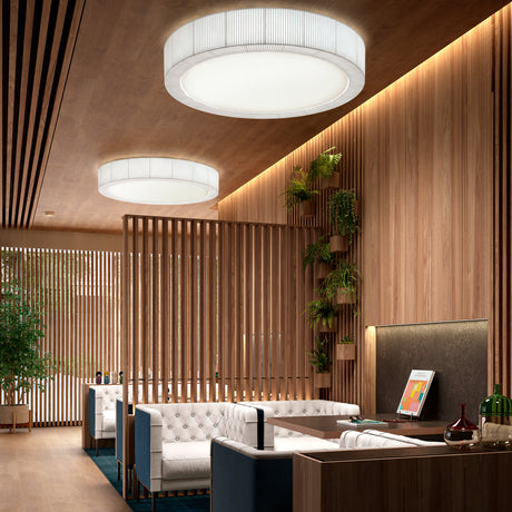 Urban PF/60 Ribbon LED ceiling lights in cream, round flush fixtures with pleated translucent shades, shown installed above a wood-panelled lounge with white sofas.