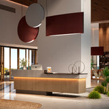 Noren S/100 fabric disc LED pendant light in terracotta with integrated warm white LED, shown above a reception desk in a modern lobby setting.
