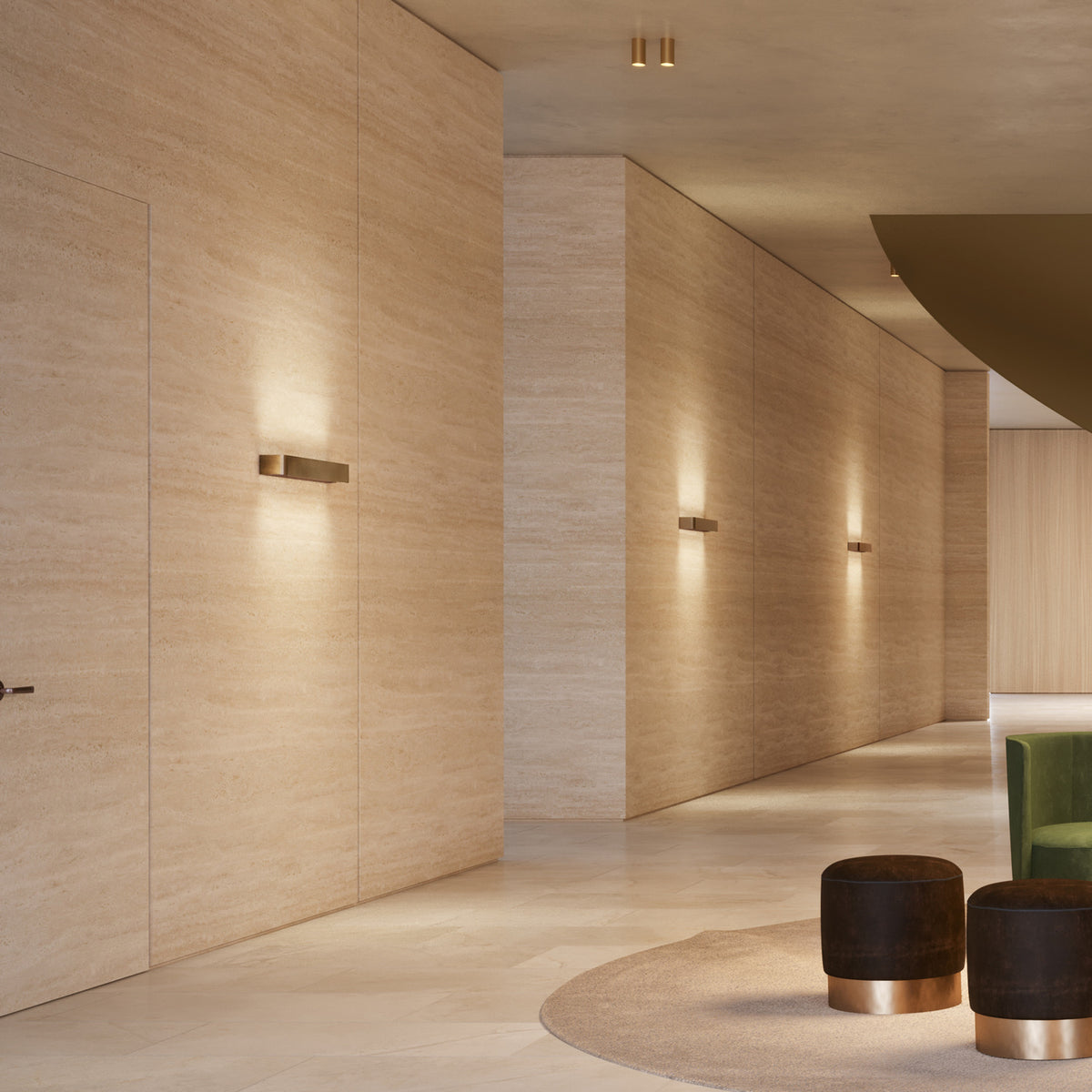 Toy R LED Wall Light 43.7cm in bronze finish mounted along a travertine corridor, its slim rectangular bar casting warm uplight and downlight on the stone wall.