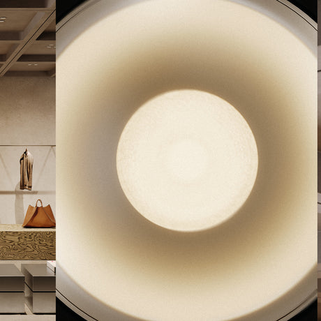 Close-up of the Bug Halo recessed LED downlight in Brushed Titanium, showing its deep round reflector glowing warm white inside a silver-grey finish, with a dim retail interior visible alongside.