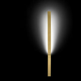 Ypsilon Brass LED Wall Light in brushed brass, a slim vertical blade fixture casting warm white ambient light up and down a dark background.