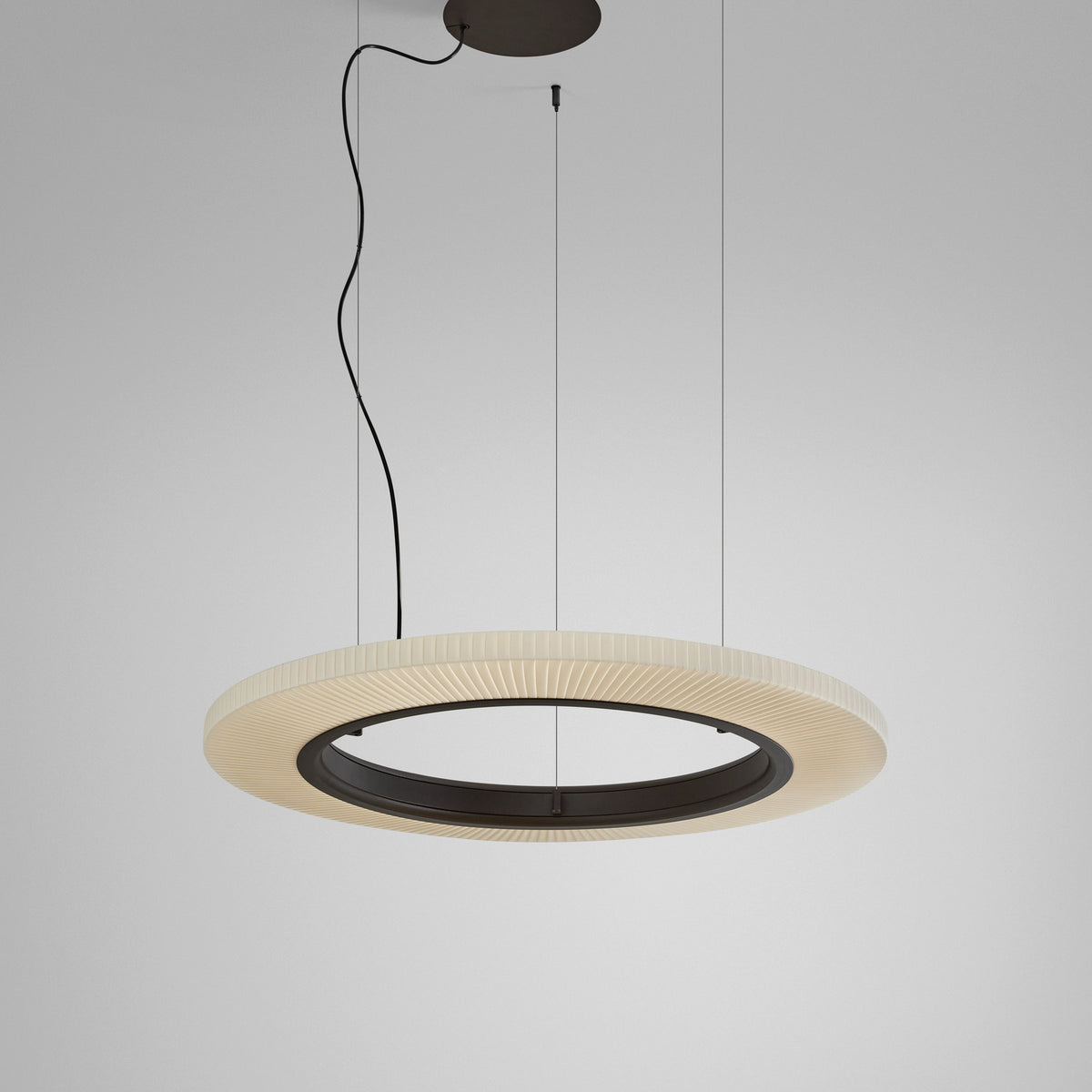 Roda S/90 Ribbon Ring LED pendant light with a cream pleated ribbon shade and dark inner ring, suspended on thin cables against a plain light grey background.