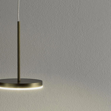 Bella Direct Aluminium LED Pendant Light in Brushed Titanium, a slim round disc on a fine stem, glowing softly against a plain grey wall.