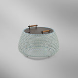 Nans Bag/38/R rechargeable outdoor floor lamp with a low, round woven basket body in beige with light blue and grey tones, dark round top and two carry handles, on a plain light background.