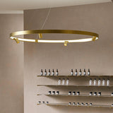 Arena Aluminium Ring LED Pendant Light 194cm in brushed brass, a large circular fixture with integrated LED strip lighting and cylindrical spotlights, shown above display shelving.