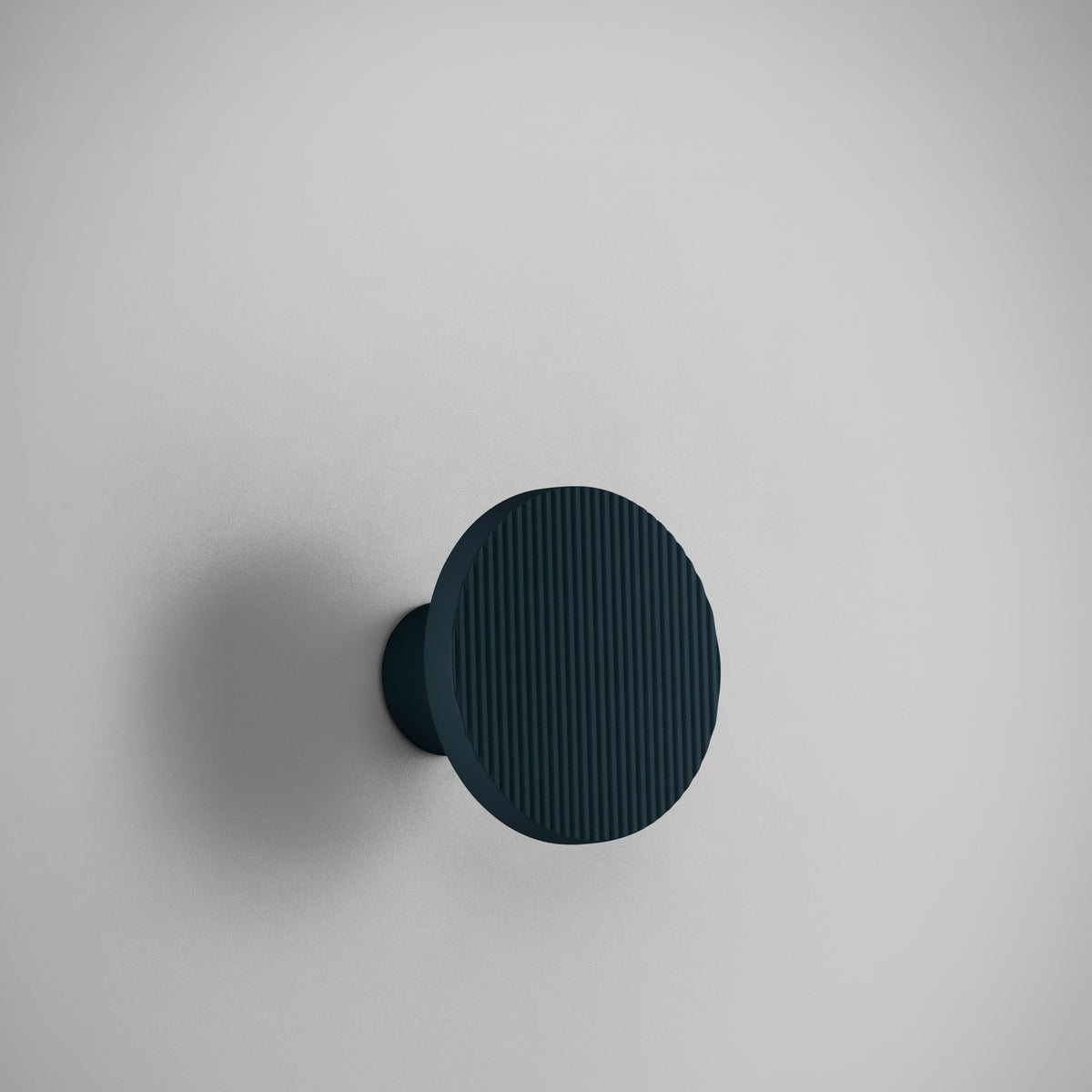 Arid A/01 round aluminium LED wall light with fluted disc face in Textured Grey Blue, mounted on a short cylindrical stem, shown against a plain light grey background.