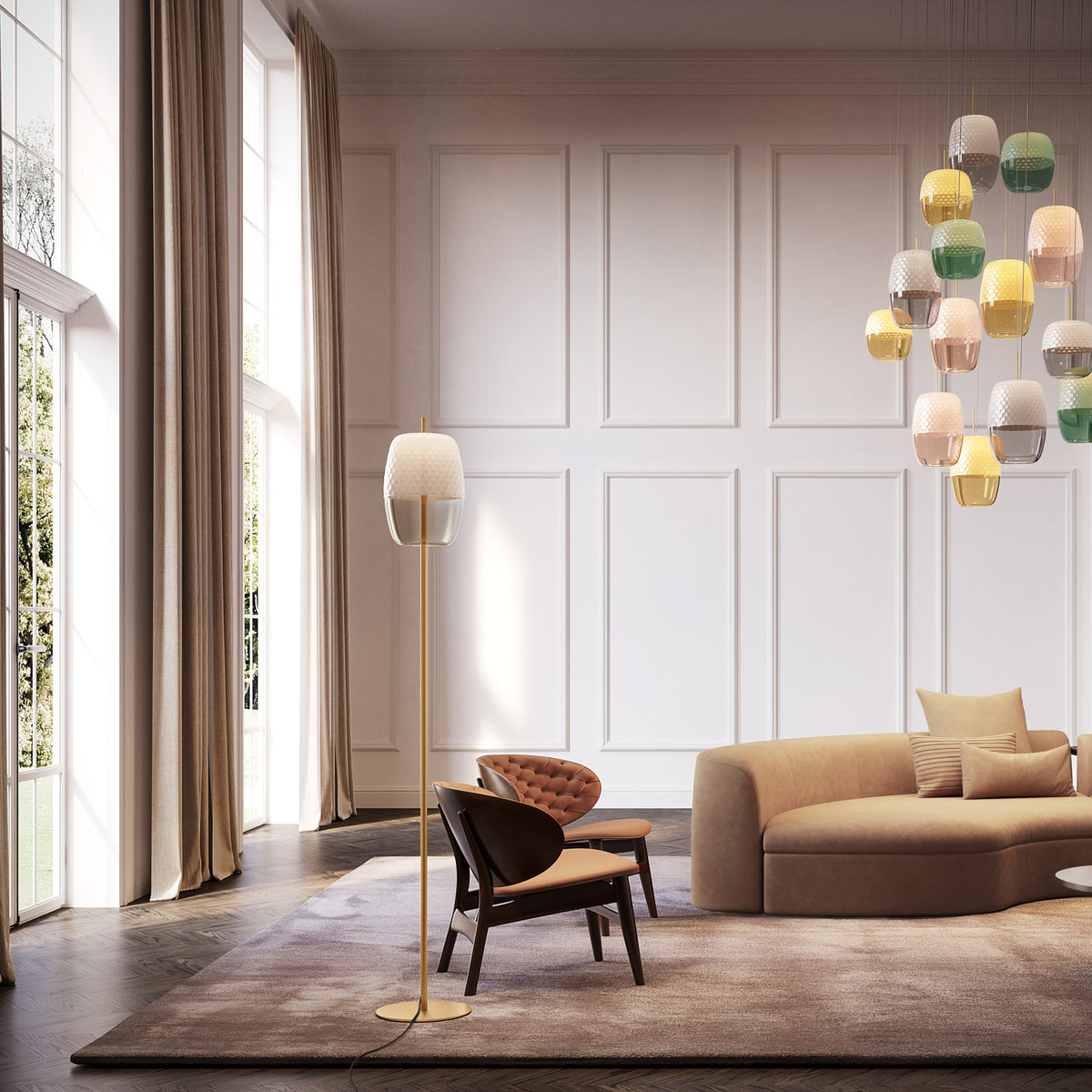 Adamas Smoke Grey glass LED floor lamp with honeycomb-faceted shade on a slim brass stem and round base, shown in a living room beside a sofa and armchairs.