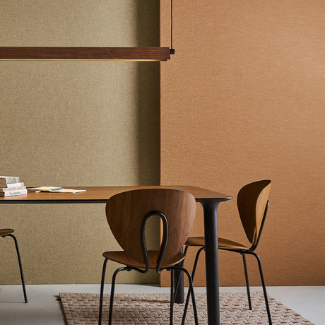 Roof S130 Casing in black and natural walnut, a slim linear pendant cover shown above a wooden dining table with two chairs in a warm-toned room.
