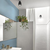 Nut PF/10 black bell-shaped LED outdoor ceiling light mounted on a white ceiling, with a matching black wall light nearby in a bathroom setting.