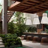 Folie S/70 Ribbon Cone pendant lights in white pleated fabric with black trim, three hung above a bar counter in a plant-filled, wood-beamed interior.