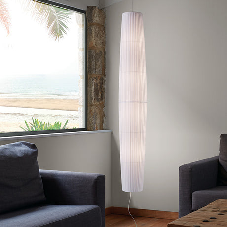 Maxi S/01 Ribbon LED pendant light in white, tall tapered column with pleated fabric and banded sections, hanging in a corner near a window in a living room.