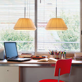 Two Mei 38 Ribbon Cone pendant lights with cream pleated ribbon cone shades, hung above a home desk with a laptop, books and a red chair.