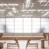 Hilow LED ceiling light with brushed titanium bars and black diffuser frames arranged in a crossing grid, installed above a lounge seating area.