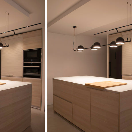 Bowee S4 4 Light Dome LED Pendant Light in matte black, four dome heads on a slim horizontal bar, shown above a kitchen island with wood cabinetry.