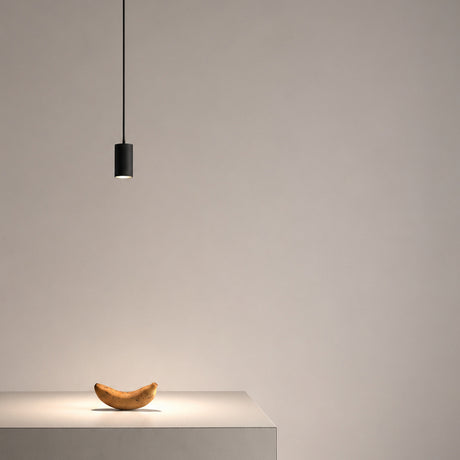 Anvil Spot SR 38° black aluminium LED pendant light with slim cylindrical head on a thin cord, casting a focused downward spotlight above a table in a neutral setting.